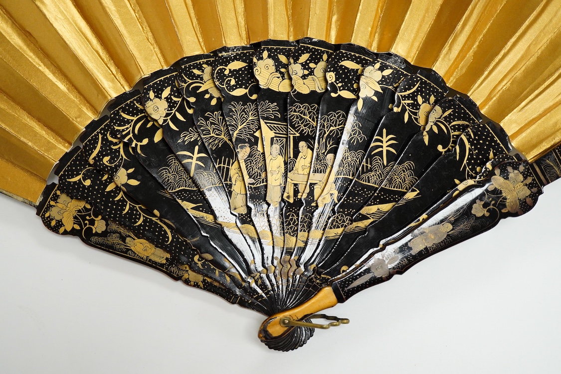 Four 19th century Chinese gilt-decorated black lacquer fans with figure painted leaves, two cased, largest 41cm